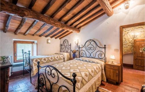 a bedroom with two beds and a wooden ceiling at Gorgeous Home In Capolona in Capolona