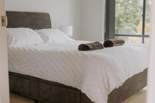 a bed with two rolled up towels on it at Soulty Vibes in Coffin Bay