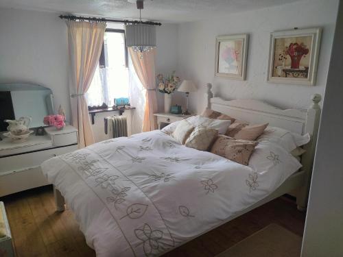 une chambre avec un lit blanc et une fenêtre dans l'établissement Maison Josselin proche château, à Josselin