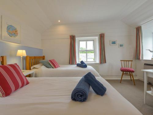 ein Schlafzimmer mit zwei Betten und einem Fenster in der Unterkunft Little Barn Cottage in Portloe