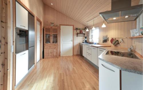 a kitchen with white cabinets and a wooden floor at Holiday Home Vinderup With Hot Tub X in Vinderup