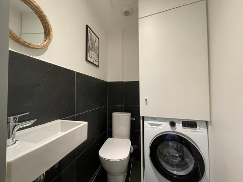 une salle de bain avec une machine à laver et un lavabo dans l'établissement Homency - Résidence de l'Oisans F1, à L'Alpe-d'Huez