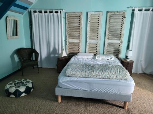 une chambre avec un lit, une chaise et des fenêtres dans l'établissement Penty breton,océan plages et petits ports à 15 minutes, à Riec-sur-Bélon