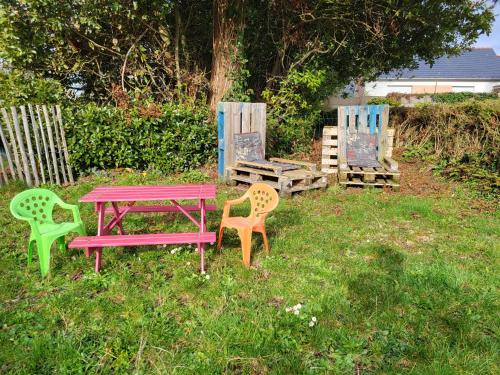 une table de pique-nique et des chaises assises dans l'herbe dans l'établissement Penty breton,océan plages et petits ports à 15 minutes, à Riec-sur-Bélon