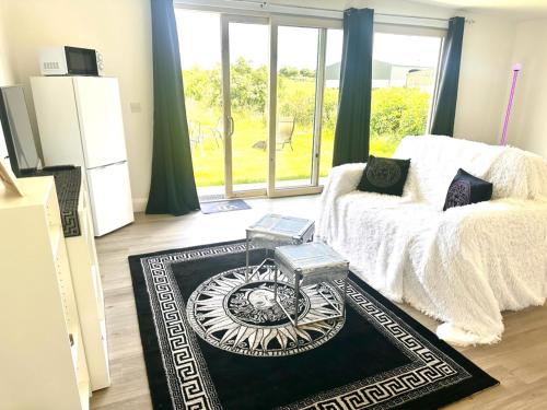 a living room with a bed and a large window at Kildare Luxury Suites in Kildare