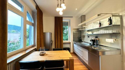 a kitchen with a wooden table and a kitchen with windows at Historical Luxury Homes - Luxus Loft Wallstreet in Freiburg im Breisgau