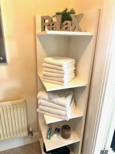 a towel shelf with towels on it in a bathroom at Kildare Luxury Suites in Kildare