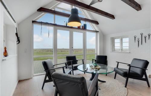 a dining room with a glass table and black chairs at Lovely Home In Ringkøbing With Wifi in Klegod