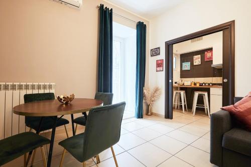 un soggiorno con tavolo e sedie e una cucina di Vicky's Luxury Guesthouse by NapoliApartments a Napoli