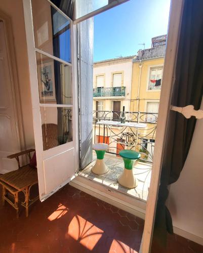 une fenêtre ouverte avec deux vases sur un balcon dans l'établissement Le Palais 10, Superbe appartement d'Exception Authentique Centre Historique, à Sète