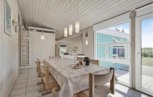 a dining room with a table and some chairs at Holiday Home Kaskelotvej Løkken Xi in Lønstrup