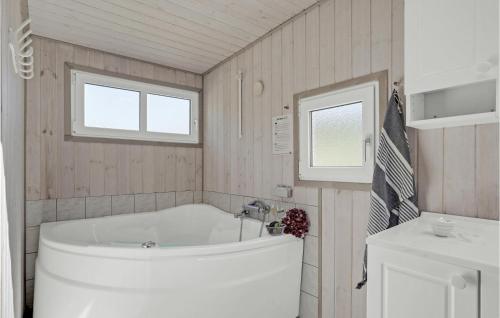 a bathroom with a tub and a toilet and a sink at Holiday Home Kaskelotvej Løkken Xi in Lønstrup