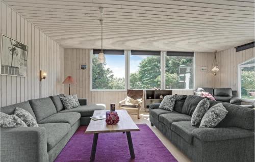 a living room with two couches and a table at Holiday Home Kaskelotvej Løkken Xi in Lønstrup