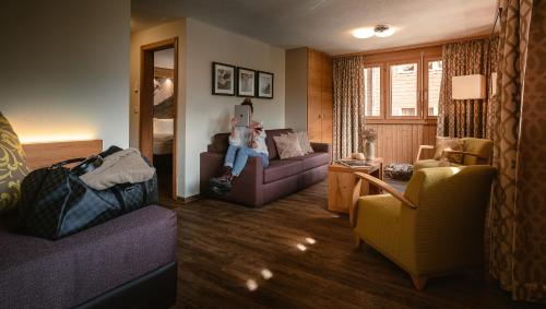 a girl sitting on a couch in a living room at Hotel Landhaus in Münster