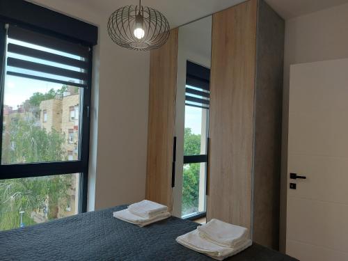 a bedroom with a bed with two towels on it at Opus Deluxe- SELF CHECK-IN, CLOSE TO OPUS ARENA in Osijek
