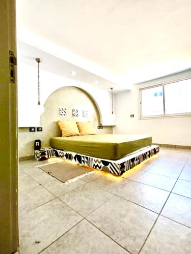a bedroom with a bed in the middle of a room at Dar ayed - proche plage in Mezraya