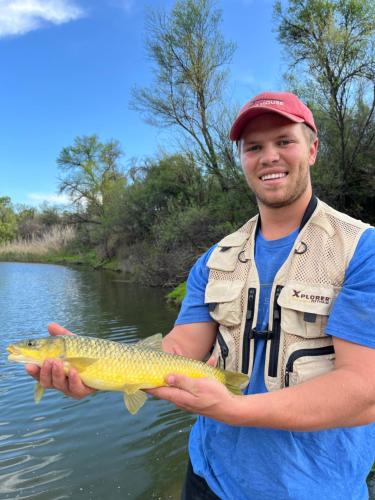 a man holding a fish in his hands on a river at Tzamenkomst River Lodge in Colesberg