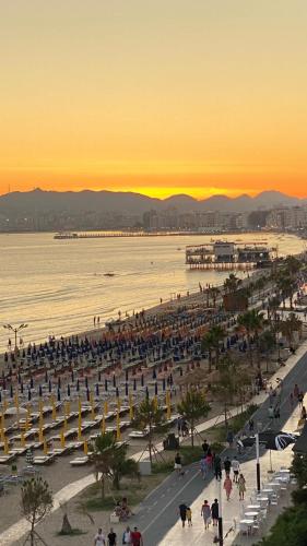 a view of a beach at sunset with people walking at Wave Beachfront Apartments in Durrës