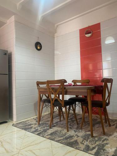 uma sala de jantar com mesa e cadeiras de madeira em Appartement Artisanale em Salé