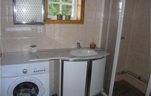 a bathroom with a sink and a washing machine at 2 Bedroom Amazing Home In Åsenhöga in Ekhult