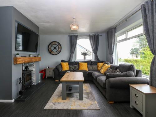 a living room with a couch and a table at Haul a Gwynt in Benllech