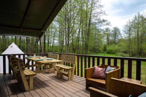 a wooden deck with a table and chairs on it at Landgut Girtenmühle in Britten