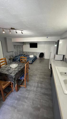 a room with a table and a kitchen and a bedroom at chambres d'hôtes en rez de villa avec piscine in Antibes