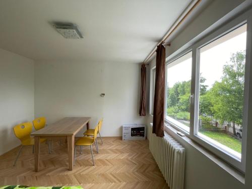 Un comedor con mesa y sillas y una gran ventana. en Vazdušna Banja Okean Ljubavi, en Soko Banja