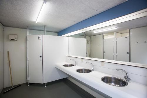 a bathroom with two sinks and a large mirror at Landgut Girtenmühle in Britten