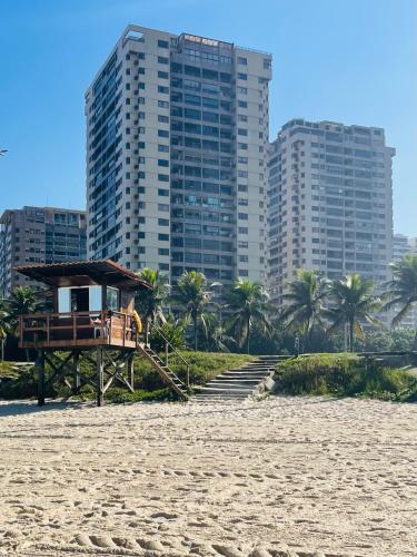 a lifeguard station on a beach with tall buildings at Maravilhoso apartamento na orla da Barra da Tijuca in Rio de Janeiro