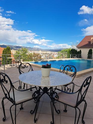 a table and chairs on a patio with a pool at Hotel Marica in Niš