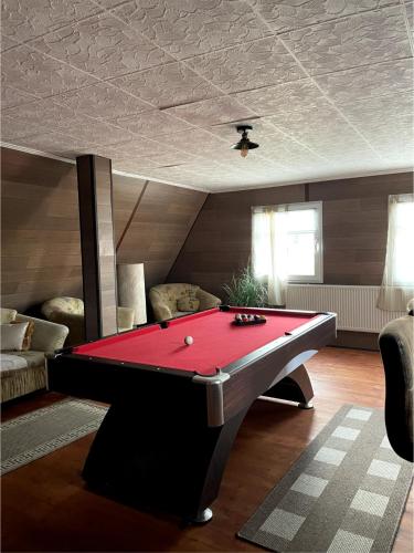 a red pool table in a living room at Haus mit Pool Großschönau in Großschönau