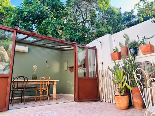 d'une porte-fenêtre avec une table et des chaises. dans l'établissement Maison atypique au coeur de Montpellier, cours et parking, à Montpellier
