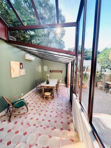 une pièce avec une table et une grande fenêtre dans l'établissement Maison atypique au coeur de Montpellier, cours et parking, à Montpellier