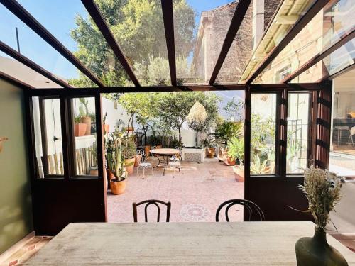 une salle à manger avec une table et une terrasse dans l'établissement Maison atypique au coeur de Montpellier, cours et parking, à Montpellier