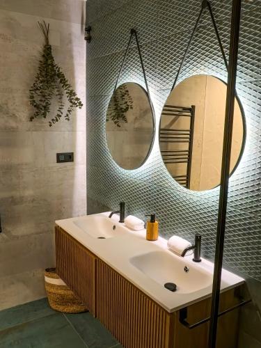 a bathroom with a sink and two mirrors at Las Horneras de Cobeta Apartamento Martina in Cobeta