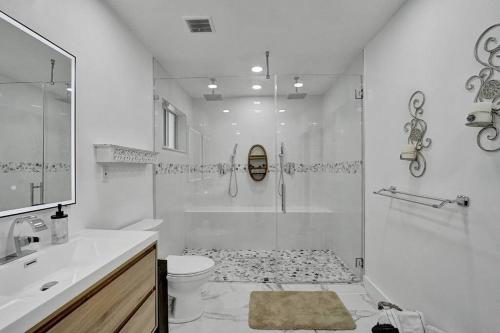 Un baño blanco con ducha y WC. en Beautiful Tropical Vacation House close to Beach, en Hollywood