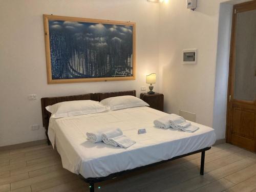 a bedroom with a bed with two towels on it at Per Due in Porto Santo Stefano