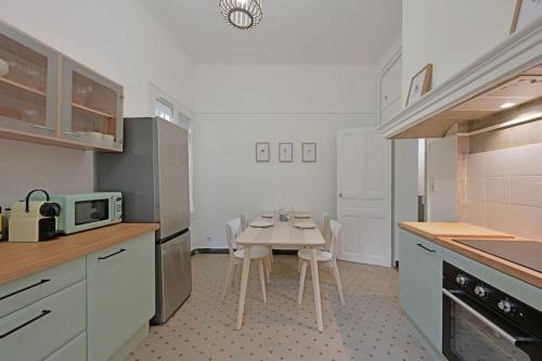 une cuisine avec une table et des chaises dans l'établissement Le Banastier - AC CLIM - Wi-Fi - Palais des Papes à 200m, à Avignon