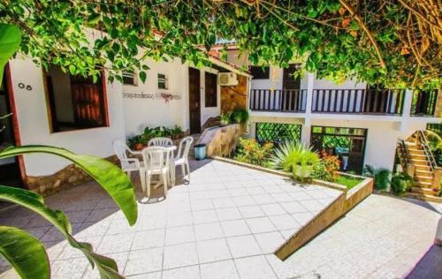 a patio of a house with a table and chairs at Pousada da Tia Glória in Morro de São Paulo