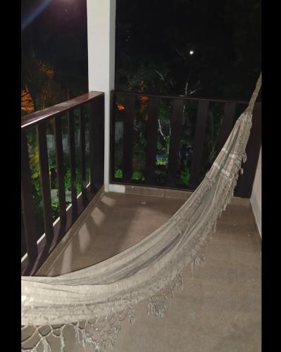 a hammock on a balcony at night at Pousada da Tia Glória in Morro de São Paulo