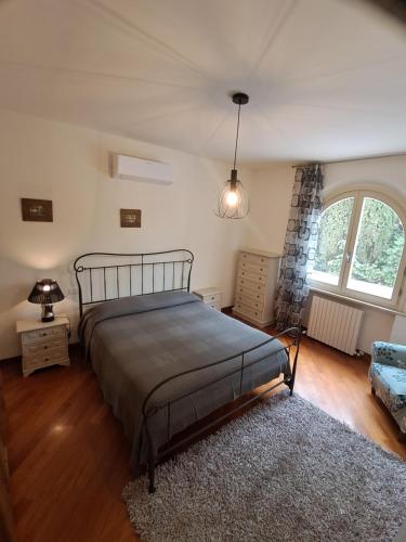 a bedroom with a bed and a large window at Biancolilla House in Rosignano Solvay