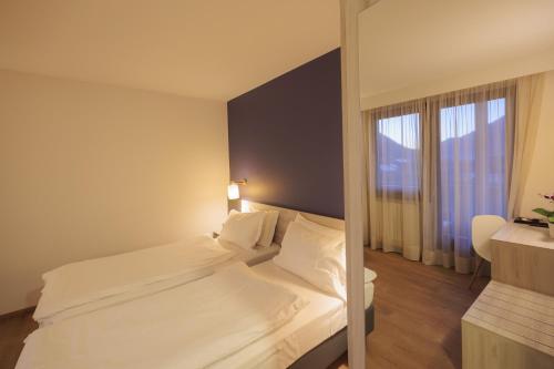 a hotel room with a bed and a window at Hotel Binelli in Pinzolo