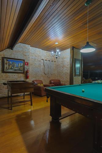 a living room with a pool table in it at Pousada Cantos e Contos in Monte Verde