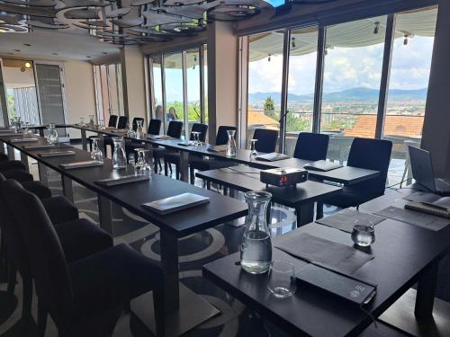 a conference room with tables and chairs and windows at Hotel Marica in Niš