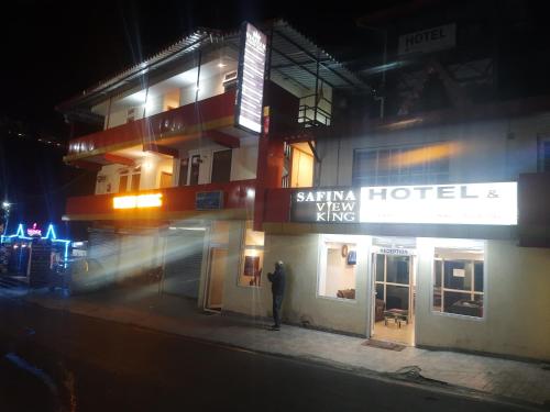 a man standing in front of a hotel at night at SAFINA VIEW KING Hotel in Bhowāli