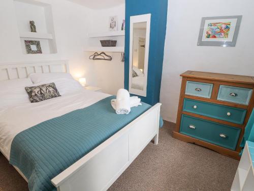 een slaapkamer met een bed, een ladekast en een spiegel bij Kestrel Cottage in Keswick