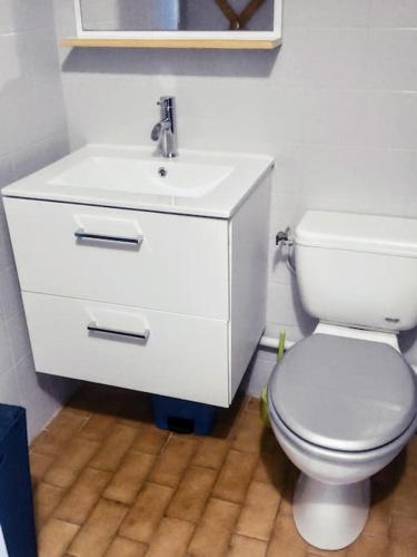 une salle de bain avec des toilettes blanches et un lavabo dans l'établissement A la frégate Port-Camargue Grau-du-Roi, au Grau-du-Roi