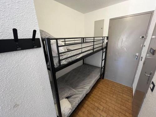 a bunk bed in a room with a door at A la frégate Port-Camargue Grau-du-Roi in Le Grau-du-Roi