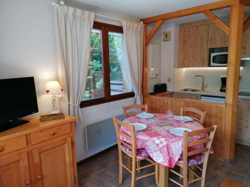 une cuisine avec une table et des chaises et une cuisine avec un évier dans l'établissement Appt 2 pièces pour 5 pers avec balcon et parking à Chinaillon, près des pistes - FR-1-241-121, au Grand-Bornand